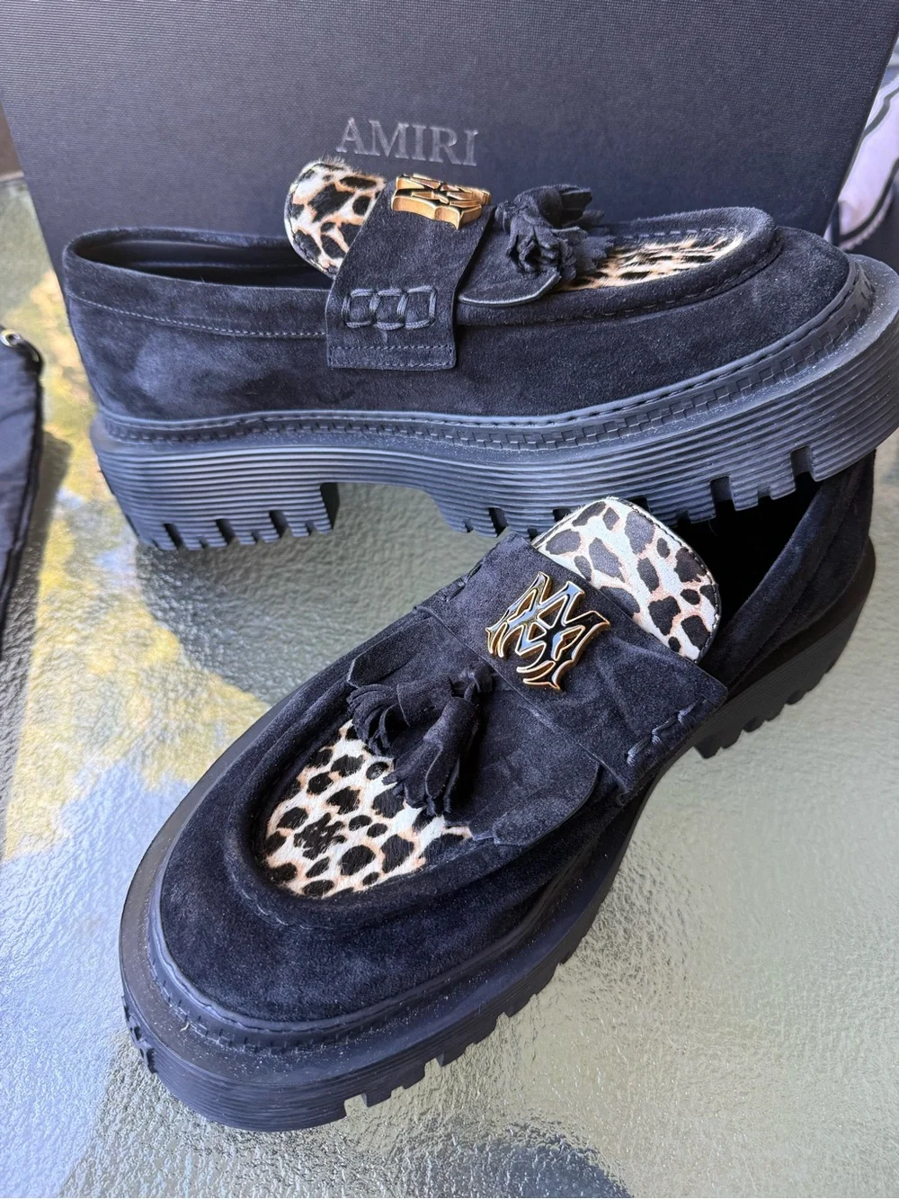 AMIRI Black Suede Tassel Loafers with Leopard Accent and Gold Crest